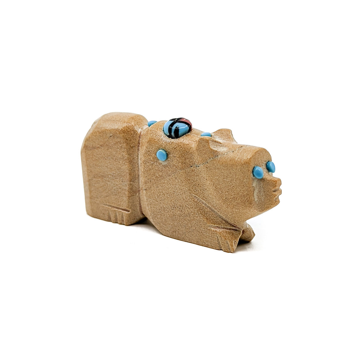 Sandstone Bear with Turquoise eyes and accents, adorned with a Jet, Turquoise, and Red Coral Zuni Sun Face&nbsp;  Bears are associated with healing and protection Measures approximately 1.5 inches long x .25 inches wide x .75 inches high