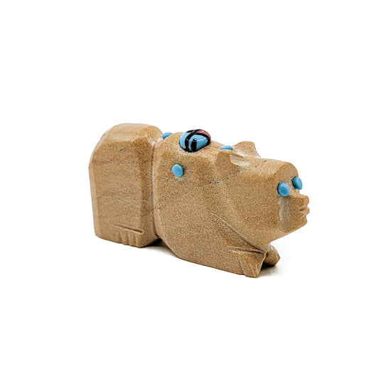 Sandstone Bear with Turquoise eyes and accents, adorned with a Jet, Turquoise, and Red Coral Zuni Sun Face&nbsp;  Bears are associated with healing and protection Measures approximately 1.5 inches long x .25 inches wide x .75 inches high